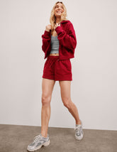 red mid rise sweat shorts with a 3.5" inseam and pockets.